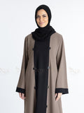 Women with dual tone Abaya black in middle and brown on both sides with white background. Clean and elegant look for casual occasions.