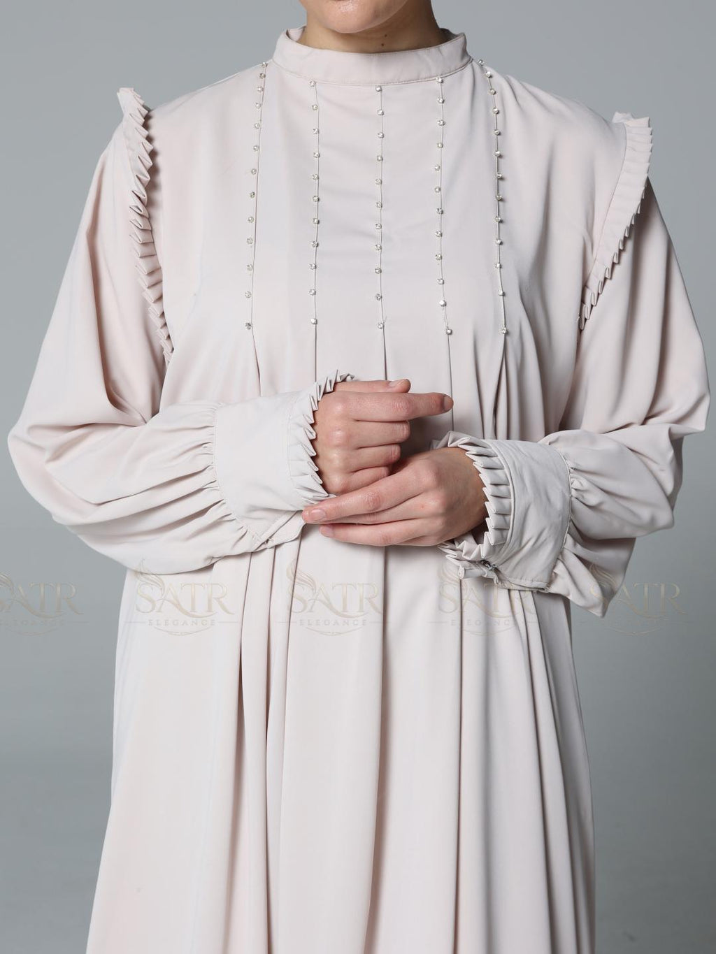 Light pink dress with ruffled details on a plain background
