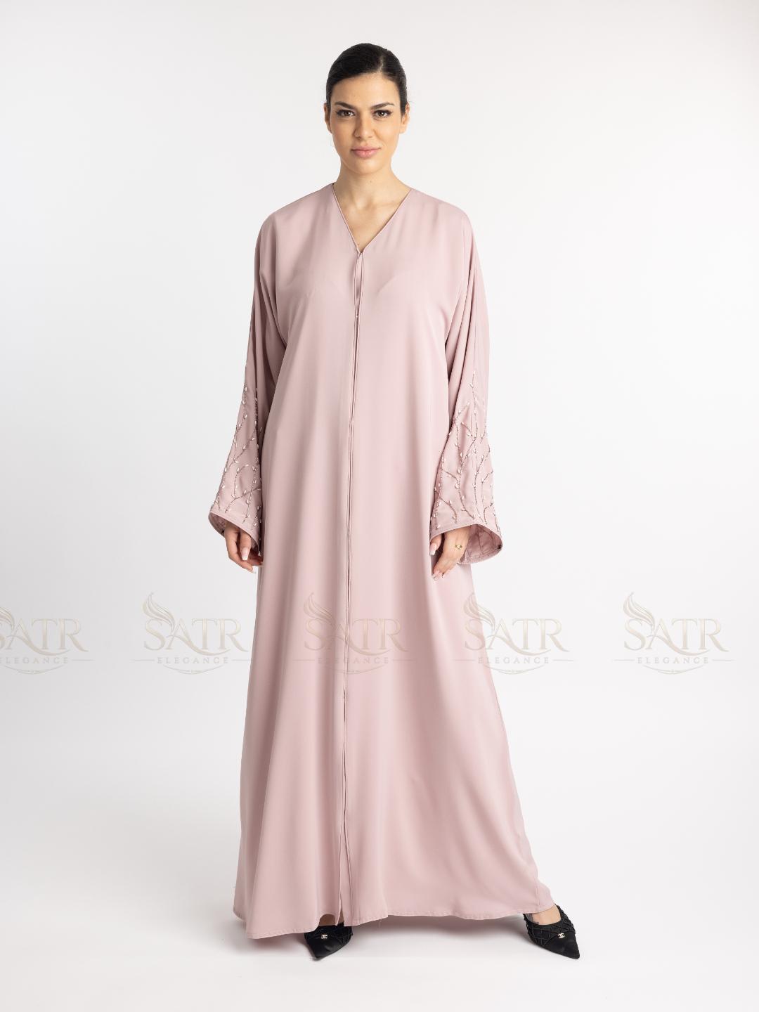 Woman wearing a long, light pink dress on a white background