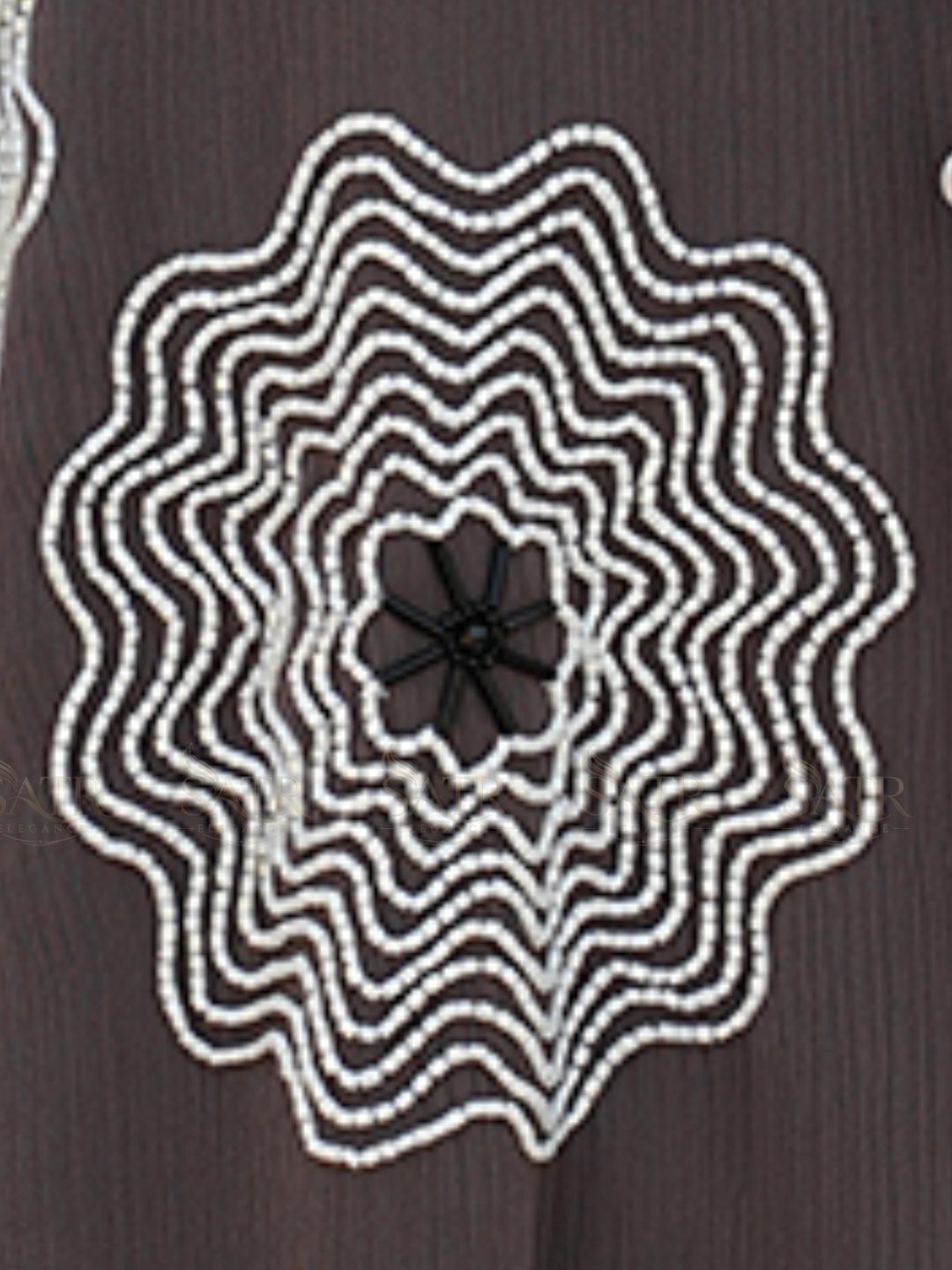 Decorative black and white pattern on a dark brown background