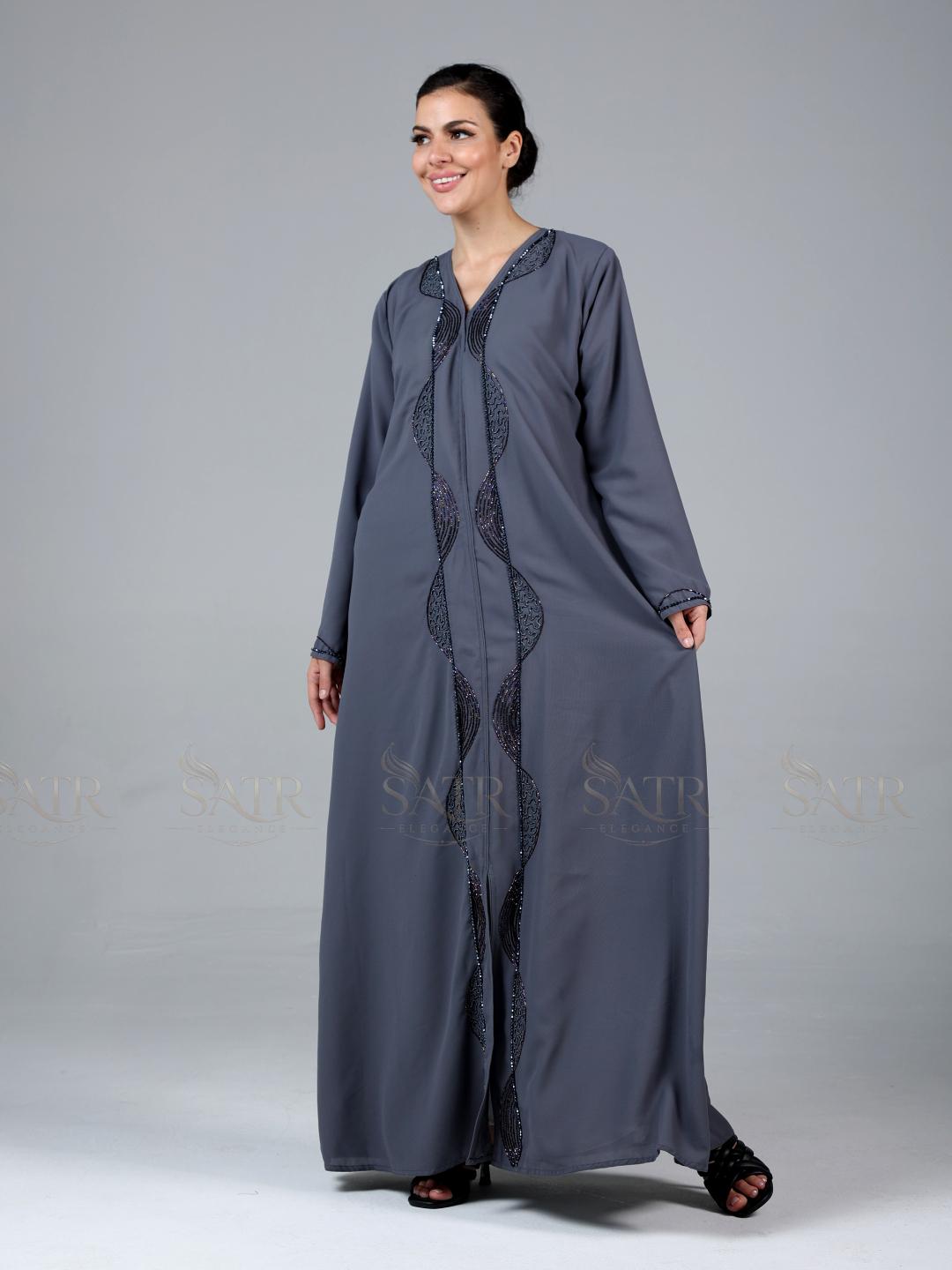Woman wearing a long gray dress with lace details on a gray background