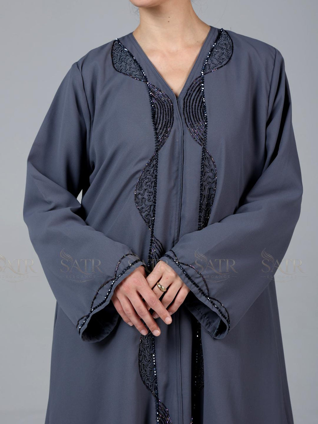 Gray traditional outfit with intricate black embroidery on a gray background