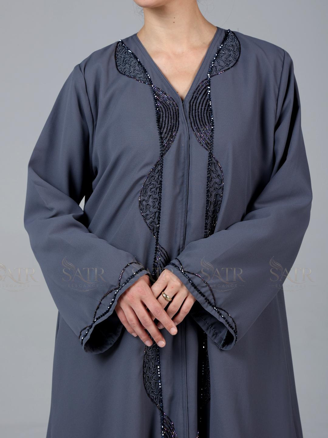 Gray traditional outfit with intricate black embroidery on a gray background