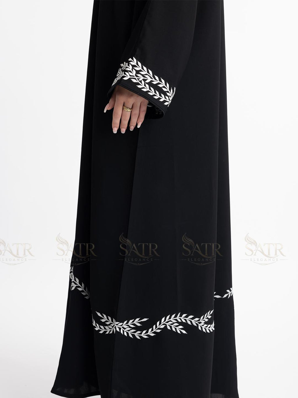 Premium black abaya with white embroidery on a white background show-casing embroidery on sleeves