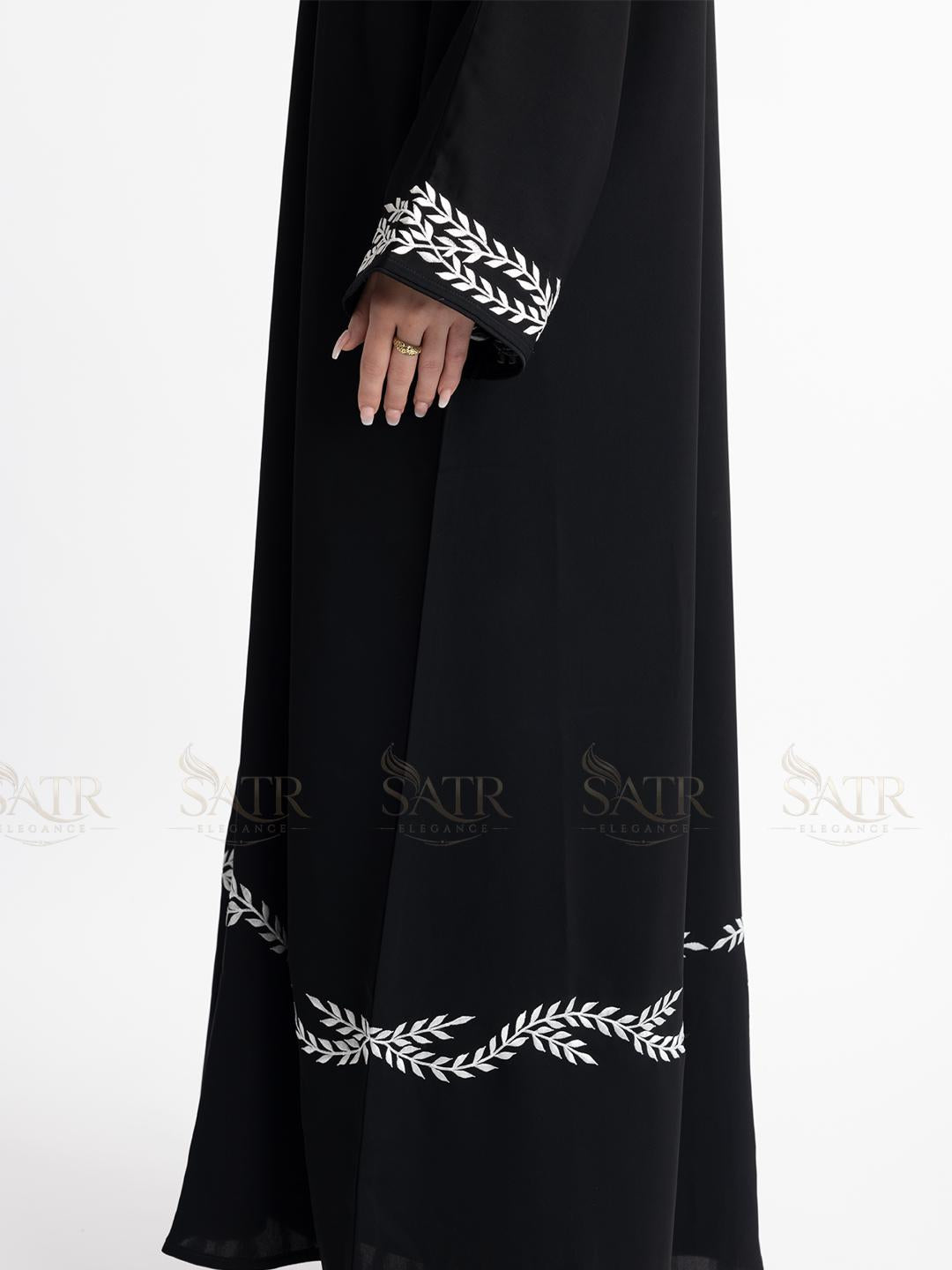 Premium black abaya with white embroidery on a white background show-casing embroidery on sleeves