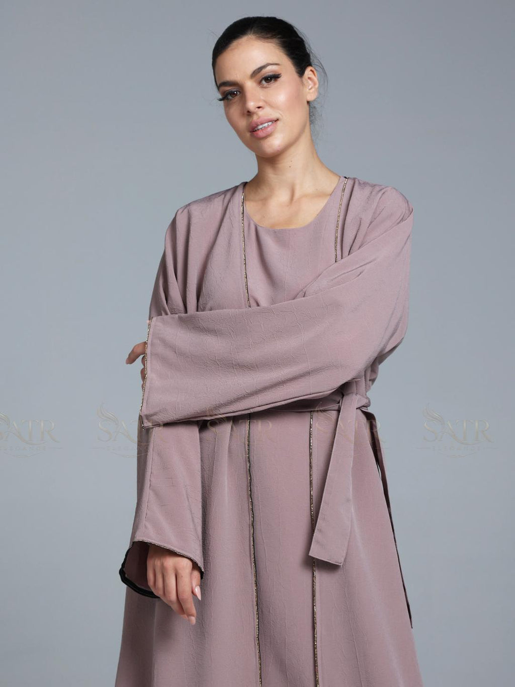 Women wearing pink abaya with small work on front pattern and grey background.