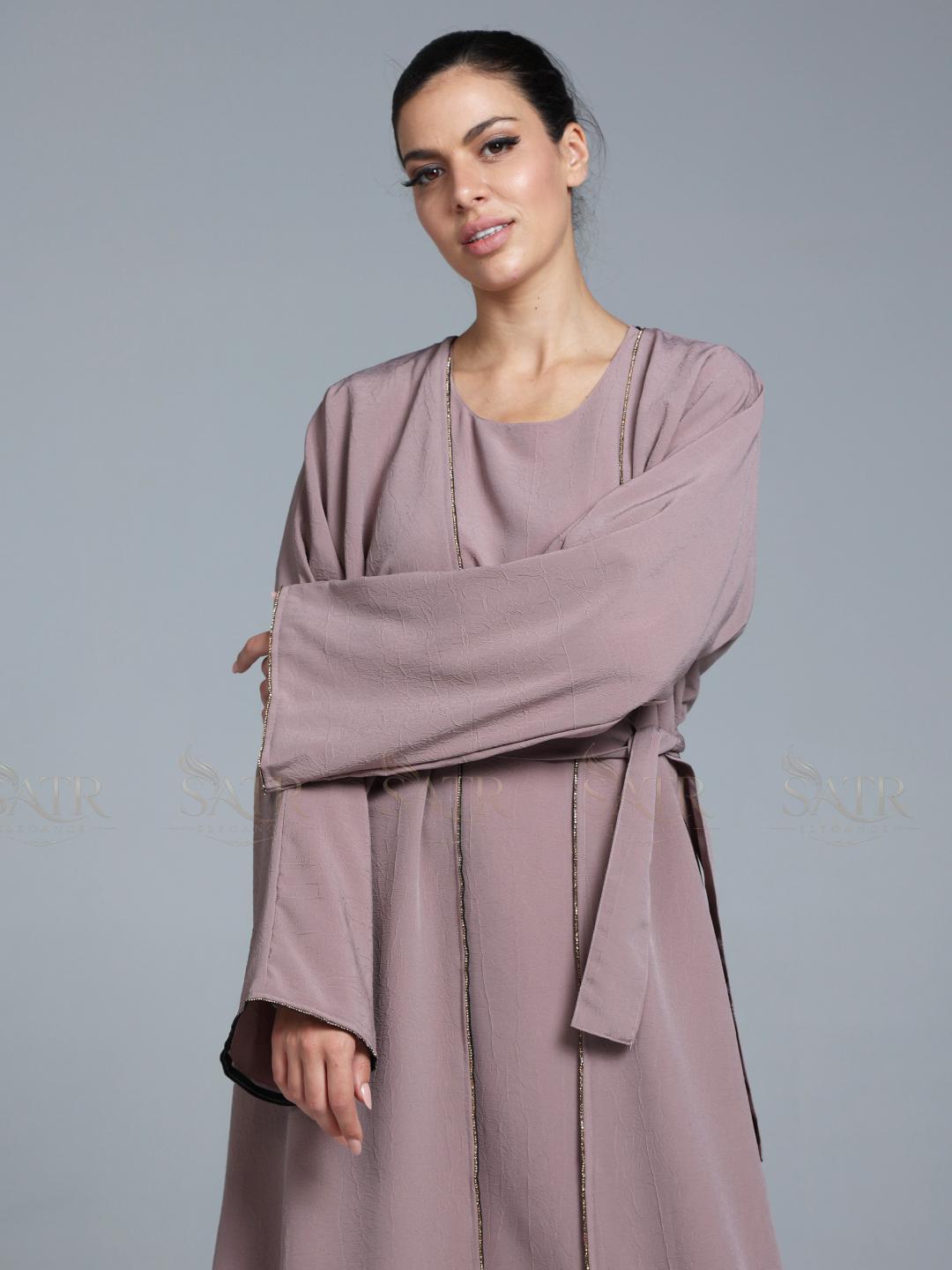 Women wearing pink abaya with small work on front pattern and grey background.