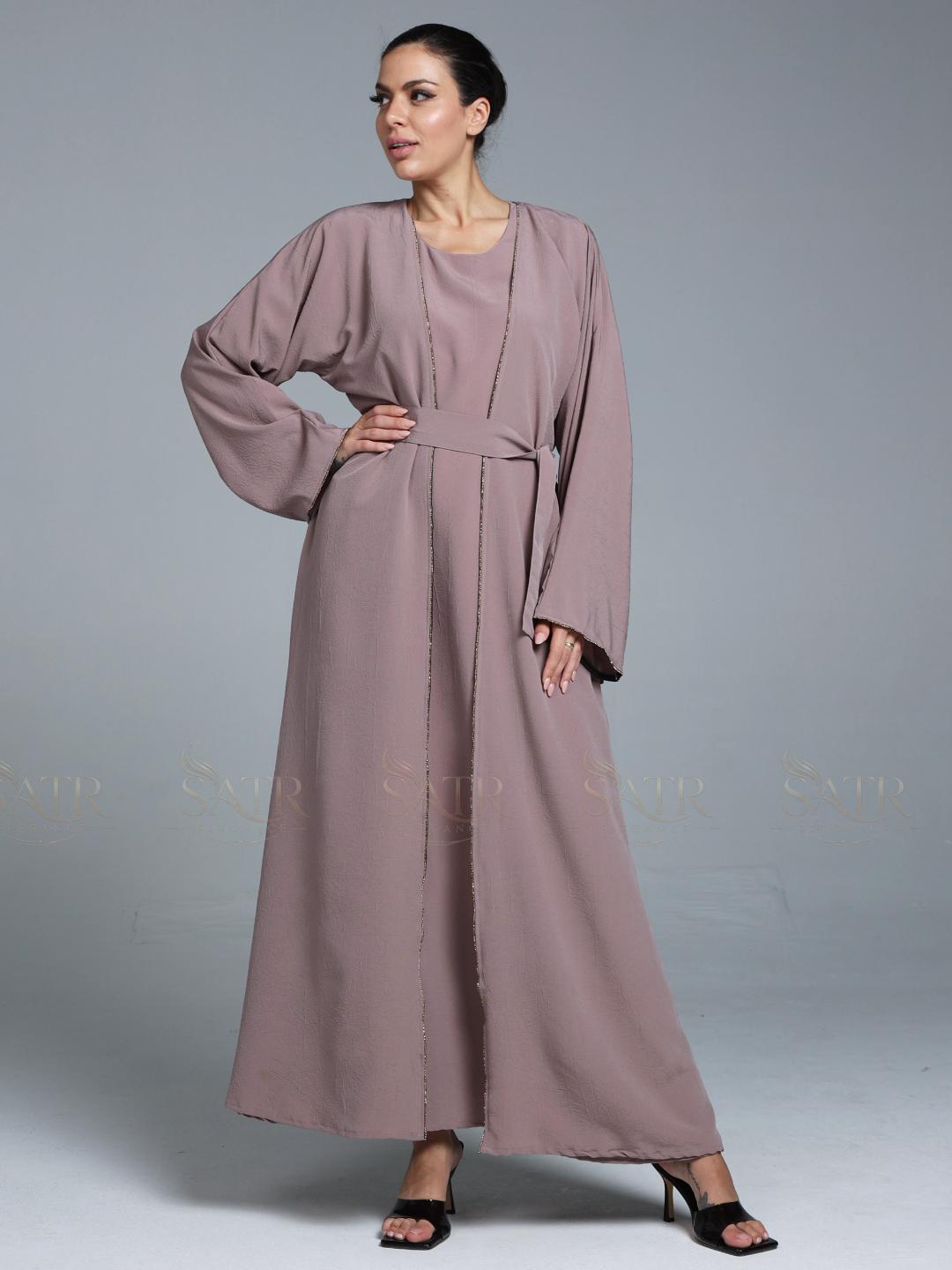 Women wearing pink abaya with small work on front pattern and grey background.