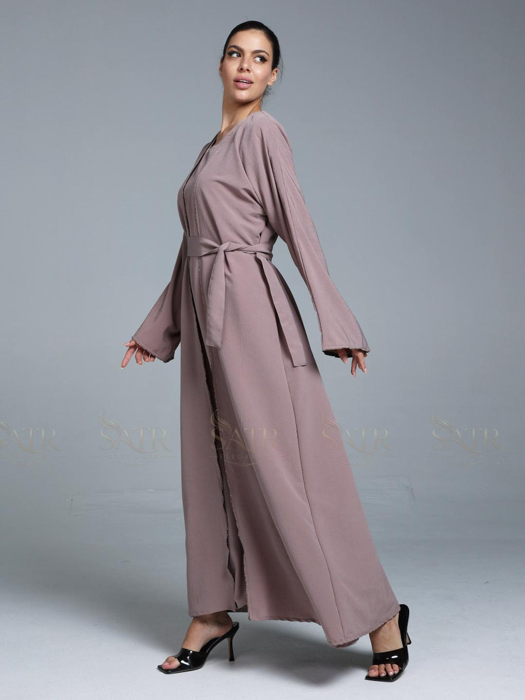Women wearing pink abaya with small work on front pattern and grey background.