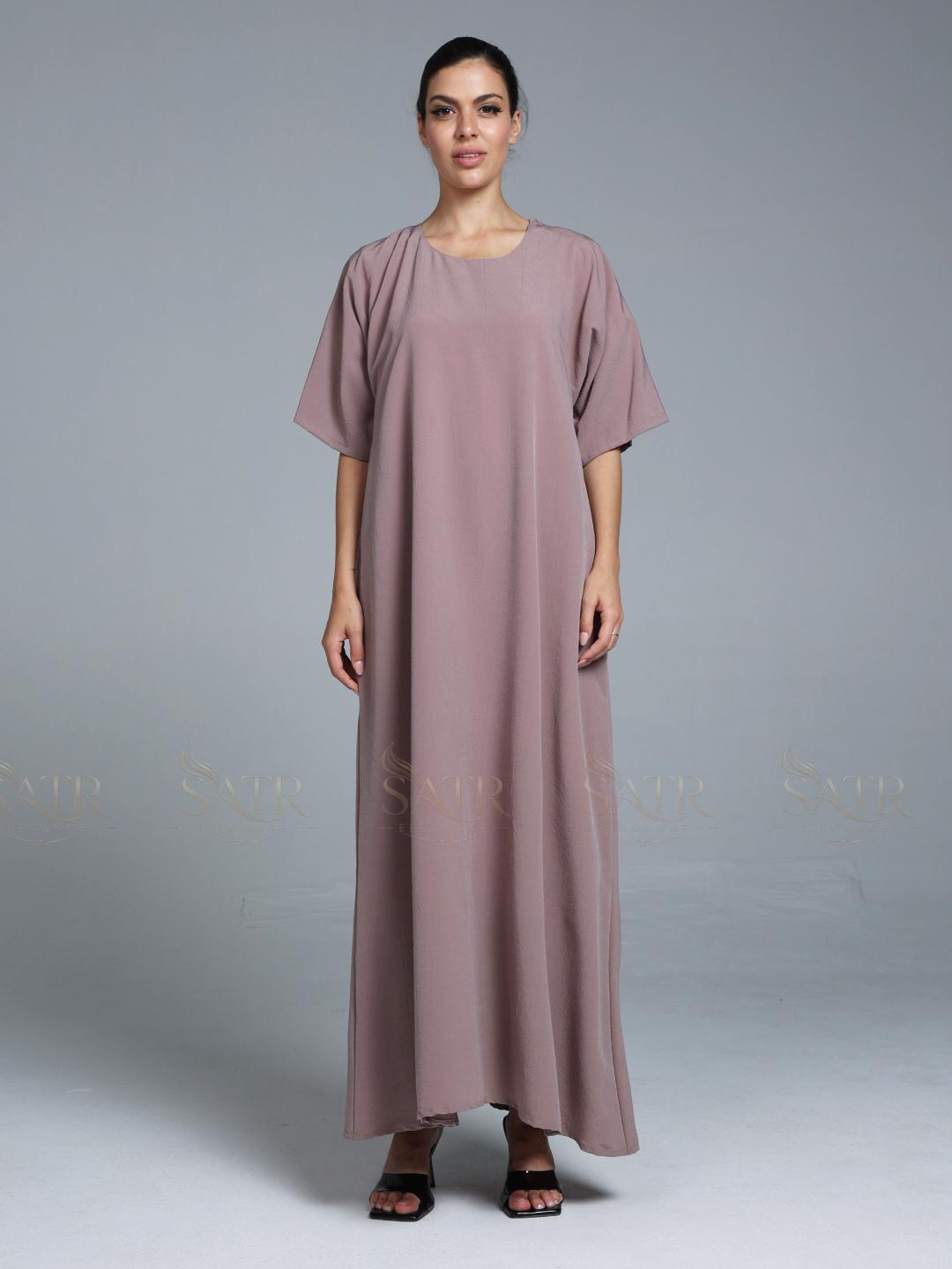 Women wearing pink abaya with small work on front pattern and grey background.