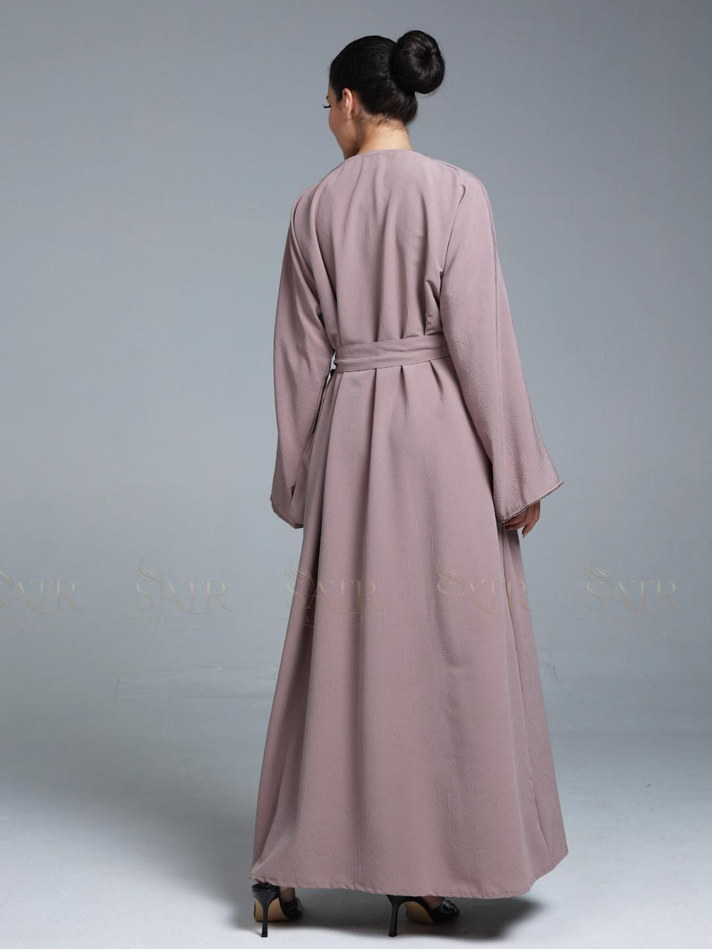 Women wearing pink abaya with small work on front pattern and grey background.
