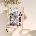 Packaged hijab pins with decorative elements on a light background