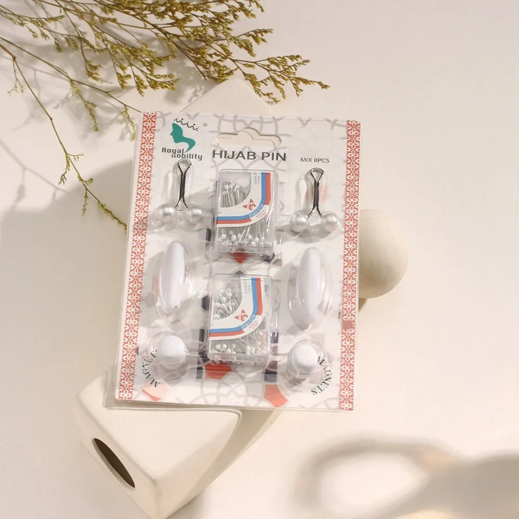 Packaged white hijab pins with a decorative box on a light background
