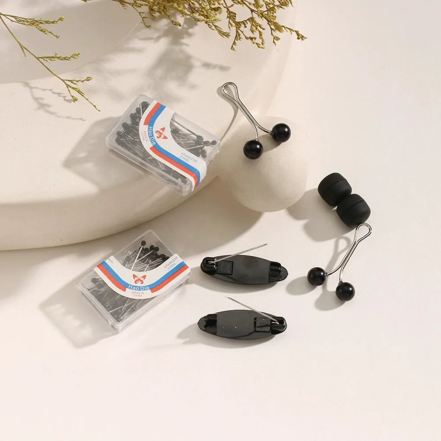 Black hair clips and clear packaging with colorful labels on a light surface.